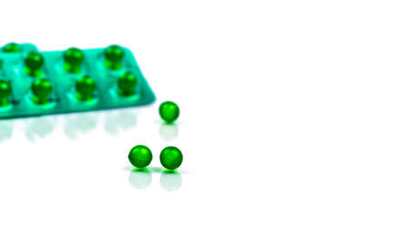 Green round soft capsule pills on blurred background of blister pack with space. Ayurvedic medicine for indigestion, gas and acidity. Herbal medicine made from Mentha oil and spearmint oil from Indiaの写真素材