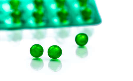 Green round soft capsule pills on blurred background of blister pack with space. Ayurvedic medicine for indigestion, gas and acidity. Herbal medicine made from Mentha oil and spearmint oil from Indiaの写真素材