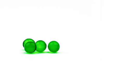 Four green round soft capsule pills isolated on white background with copy space. Ayurvedic medicine...