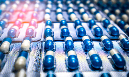 Blue and white capsules pill in blister pack arranged with beautiful pattern. Global healthcare...