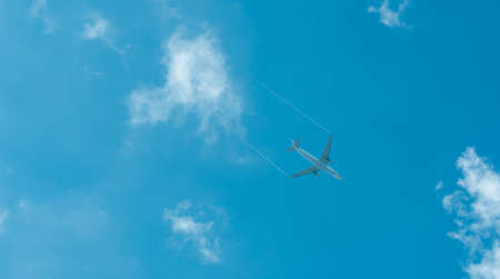 Airplane on blue sky and white clouds. Commercial airline flying on blue sky. Travel flight for vacation. Aviation transport.の写真素材