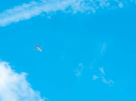 Airplane on blue sky and white clouds. Commercial airline flying on blue sky. Travel flight for...