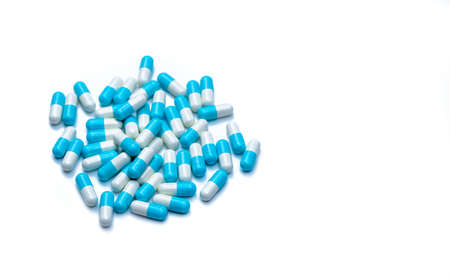Pile of blue and white capsules pill isolated on white background with copy space. Global healthcare concept. Antibiotics drug resistance. Antimicrobial capsule pills. Pharmaceutical industry.の写真素材