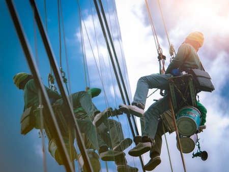 High rise window cleaner. Glass cleaner working. Most dangerous jobs in the building, cleaning and maintenance industries. Building cleaning workers. Cleaning windows service. High risk work.のeditorial素材