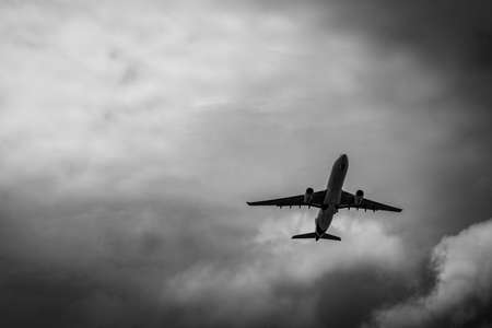 Commercial airplane on grey sky and clouds with copy space. Failed vacation. Hopeless and despair...