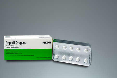 CHONBURI, THAILAND-AUGUST 3, 2018 : Reparil-Dragees. Aescin 20 mg enteric coated tablets product of Meda Pharma (Thailand). Manufactured by Madaus GmbH, Germany. White round tablets isolated on grey.のeditorial素材