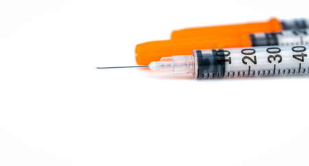 Single use syringe. Plastic insulin syringe. Needle for addict. Insulin syringe with opened cover...
