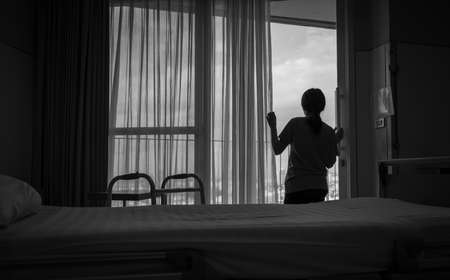 Sad adult Asian woman looking out of window and thinking. Stressed and depressed young woman....