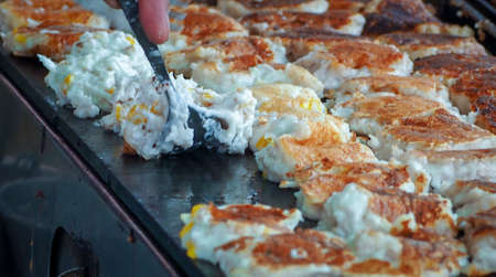 Khanom Babin. Thai desserts. Coconut pancake. Thai food sellers use spoon to flip coconut pancake on hot stove. Thai candy. Freshly made dessert at street food in Thailand. Thai style pancakes.の写真素材