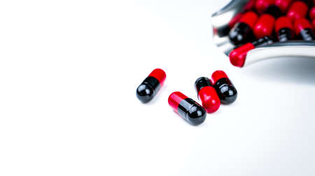 Red and black capsule pills on drug tray. Antibiotics drug resistance. Global healthcare....
