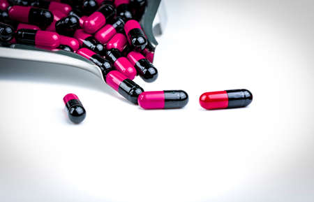 Pink-black capsule pills on drug tray. Antibiotics drug resistance. Global healthcare. Antimicrobial...