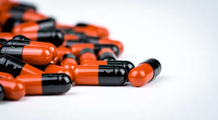 Selective focus on orange-black capsule pills. Antibiotics drug resistance. Drug use with...
