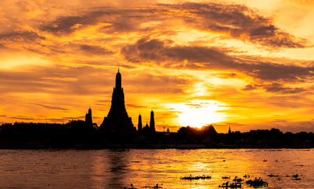 River and Wat Arun Ratchawararam at sunset with beautiful  orange sky and clouds. Wat Arun buddhist...