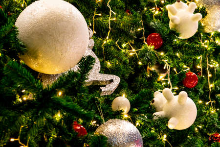 Close up Christmas tree decoration with red, gold, silver, and white balls, silver star and white...