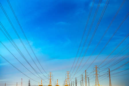 High voltage electric pole and transmission lines in the evening. Electricity pylons at night. Power...