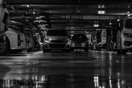 Selective focus on car parking in the shopping mall. Car parked overnight. Indoor car parking. Automobile parking space. Underground car parking lot in the night. Robbery. Automobile thief at mall.の写真素材
