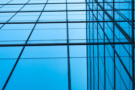 Perspective view of modern futuristic  glass building abstract background. Exterior of office glass building architecture. Reflection in transparent glass of business building. Company glass window.の写真素材