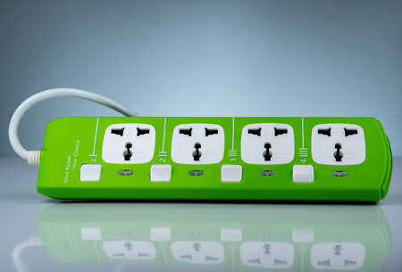 High quality and safety power strip with four electrical standard socket. Green universal plug with overload protection. Fire resistant material for cover. Circuit breaker. Individual switch.の写真素材
