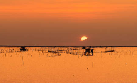 Beautiful sunset sky over the sea in the evening. The sun is obscured by some clouds at sunset....