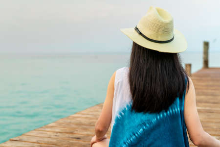 Back view of happy young Asian woman in casual style fashion and straw hat relax and enjoy holiday...