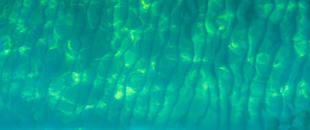 Green abstract texture background of emerald green sea water. Top view of green sea water with...