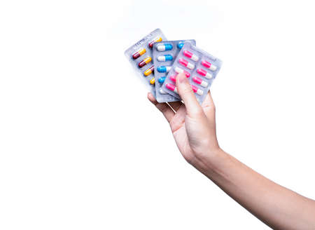 Asian adult hand holding antibiotics drug in blister pack. Woman hand hold three pack of capsule pills. Hand giving antibiotics drug isolated on white background. Antibiotic drug resistance concept.の写真素材
