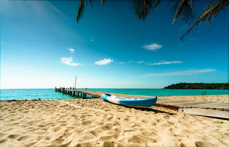 Beautiful view tropical paradise beach of resort. Coconut tree, wooden bridge, and kayak at resort...