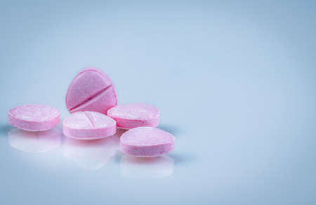 Pink tablets pills with shadow on gradient background. Pharmaceutical industry. Pharmacy products. Vitamins and supplements. Medication use in hospital or drugstore. Global drug retail market.の写真素材
