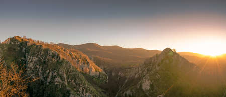 Landscape of mountain in the morning with sun light. Wind turbine on the top of mountain. Renewal...