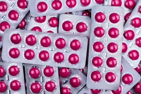 Pink tablets pill in blister pack. Painkiller medicine for treatment migraine headache and high fever. Non-steroidal Anti-inflammatory drugs (NSAIDs). Ibuprofen tablets pill. Pharmaceutical products.の写真素材