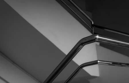 Modern stainless steel railing in house or apartment. Concrete stair with stainless stair handrail at home. Cement building indoor interior abstract. Black and white scene of stainless steel railing.の写真素材