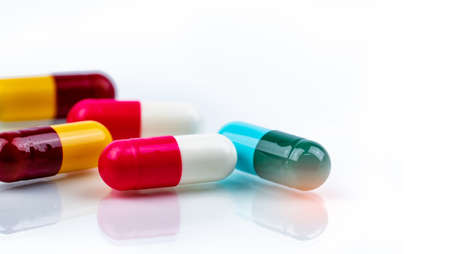 Colorful antibiotics capsule pills on white background. Antibiotic drug resistance. Pharmaceutical...