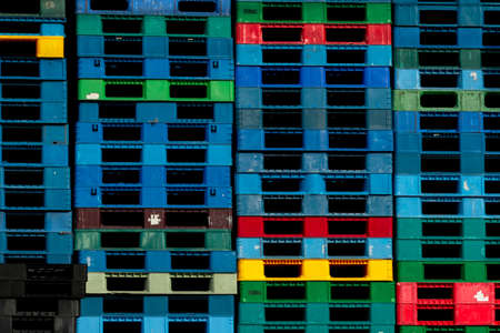 Plastic shipping pallet for sale and for rent business. Industry plastic pallet stacked at factory warehouse. Cargo and shipping business concept. Pile of plastic pallet for distribution and delivery.の写真素材