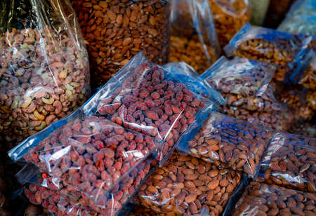 Almonds and cashew nuts in plastic bag at the market. Healthy food. High protein food for fitness or...