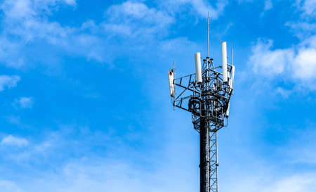 Telecommunication tower with blue sky and white clouds background. Antenna on blue sky. Radio and...