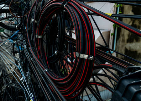 Tangled electrical wires on urban electric pole. Disorganized and messy to organization management...