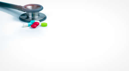 Stethoscope, capsule, and tablets pills on doctor table or nurse desk. Health checkup. Medical healthcare and medicine background. Physician tool for patient diagnosis. Cardiology doctor equipment.の写真素材