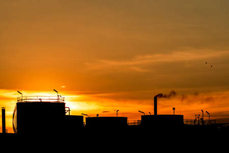 Gas turbine electrical power plant. Energy for support factory in industrial estate. Natural gas tank. Small gas power plant. Power plant using natural gas for fuel. Green energy. Dramatic sunset sky.の写真素材