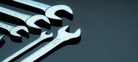 Set of chrome wrenches or spanners isolated on glass table in workshop. Chrome vanadium spanner wrench. Silver wrenches. Mechanic tools. Hardware for service technician to fix and maintenance.の写真素材