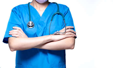 Asian doctor or nurse wear blue scrubs uniform with stethoscope. Physician stand with arms crossed isolated on white background. Healthcare professional. Health insurance concept. Expertise doctor.の写真素材