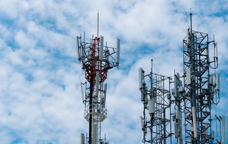 Telecommunication tower with blue sky and white clouds background. Antenna on blue sky. Radio and satellite pole. Communication technology. Telecommunication industry. Mobile or telecom 4g network.の写真素材
