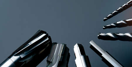 Special tools isolated on dark background. Made to order special tools. Coated step drill and reamer detail. HSS cemented carbide. Carbide cutting tool for industrial applications. Engineering tools.の写真素材