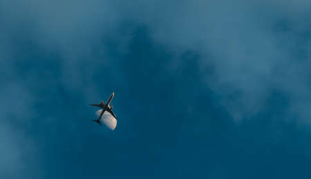 Commercial airline flying on blue sky and white clouds. Under view of airplane flying. Passenger...