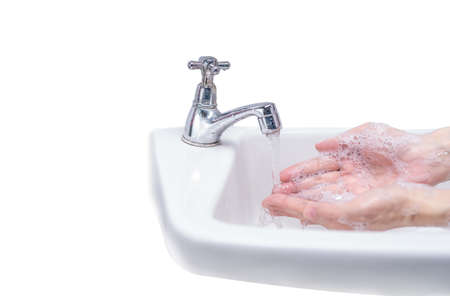 Woman washing hand with soap foam and tap water in bathroom. Hand clean under faucet on sink for personal hygiene to prevent flu and coronavirus. Good procedure of hand wash to kill bacteria, virus.の写真素材