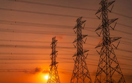 High voltage electric pylon and electrical wire with sunset sky. Electricity poles. Power and energy...