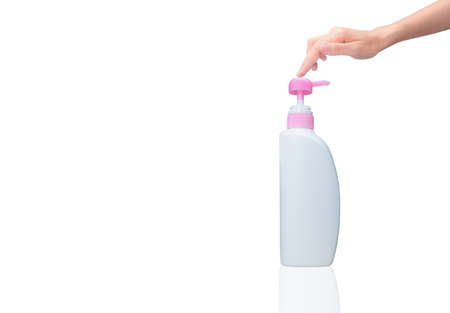 Woman hand pressed on pump cosmetic bottle isolated on white. Shampoo or hair conditioner plastic bottle and dispenser pump. Body soap or shower gel packaging. Liquid soap bottle. Body lotion bottle.の写真素材