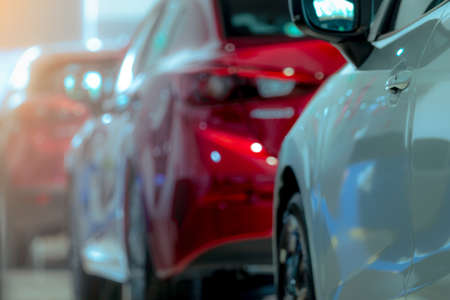 Blurred of white and red luxury car parked in modern showroom. Car dealership office. Electric car business concept. Automobile leasing. Automotive industry crisis background concept. Shiny car.の写真素材