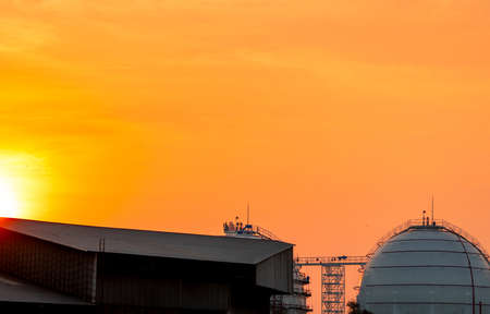 Industrial gas storage tank. LNG or liquefied natural gas storage tank. Golden sunset sky. Spherical...