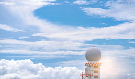 Weather observations radar dome station against blue sky and white fluffy clouds. Aeronautical meteorological observations station tower use for safety aircraft in aviation business. Spherical tower. Weather observations radar dome station against blue sky and white fluffy clouds. Aeronautical meteorological observations station tower use for safety aircraft in aviation business. Spherical tower.