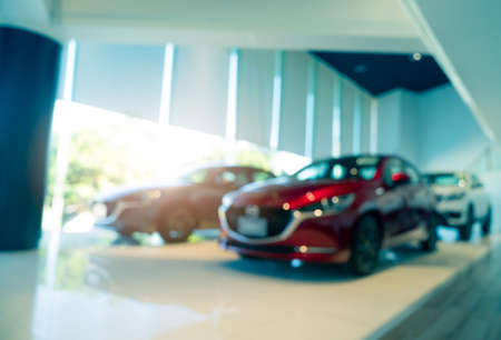 Burred SUV car parked in modern showroom. Car dealership and auto leasing concept. Automotive industry. Modern luxury showroom. Front view new car parked in showroom. Electric automobile technology.の写真素材